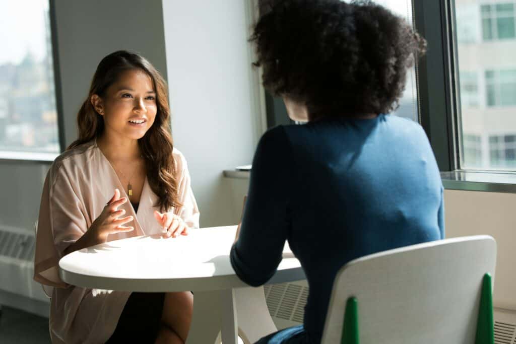 2 women at a table for an in-person job interview