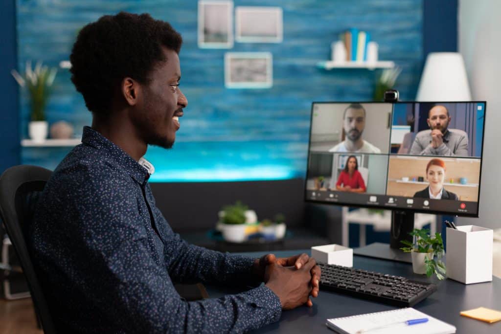 Business student having online videocall meeting conference with remote university team discussing marketing ideas in living room. Videoconference telework call on computer computer screen